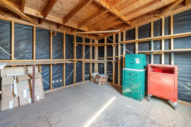 a view of an empty room with furniture and a window