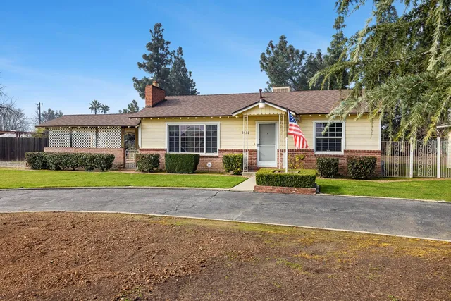 a view of a house with a yard and palm trees