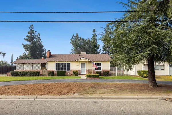 a front view of a house with a garden and plants