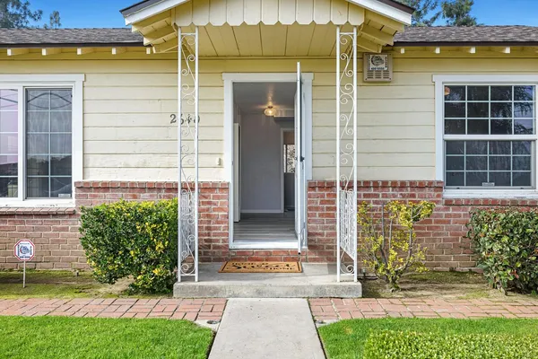 a view of a hallway with wooden floor and a bathroom