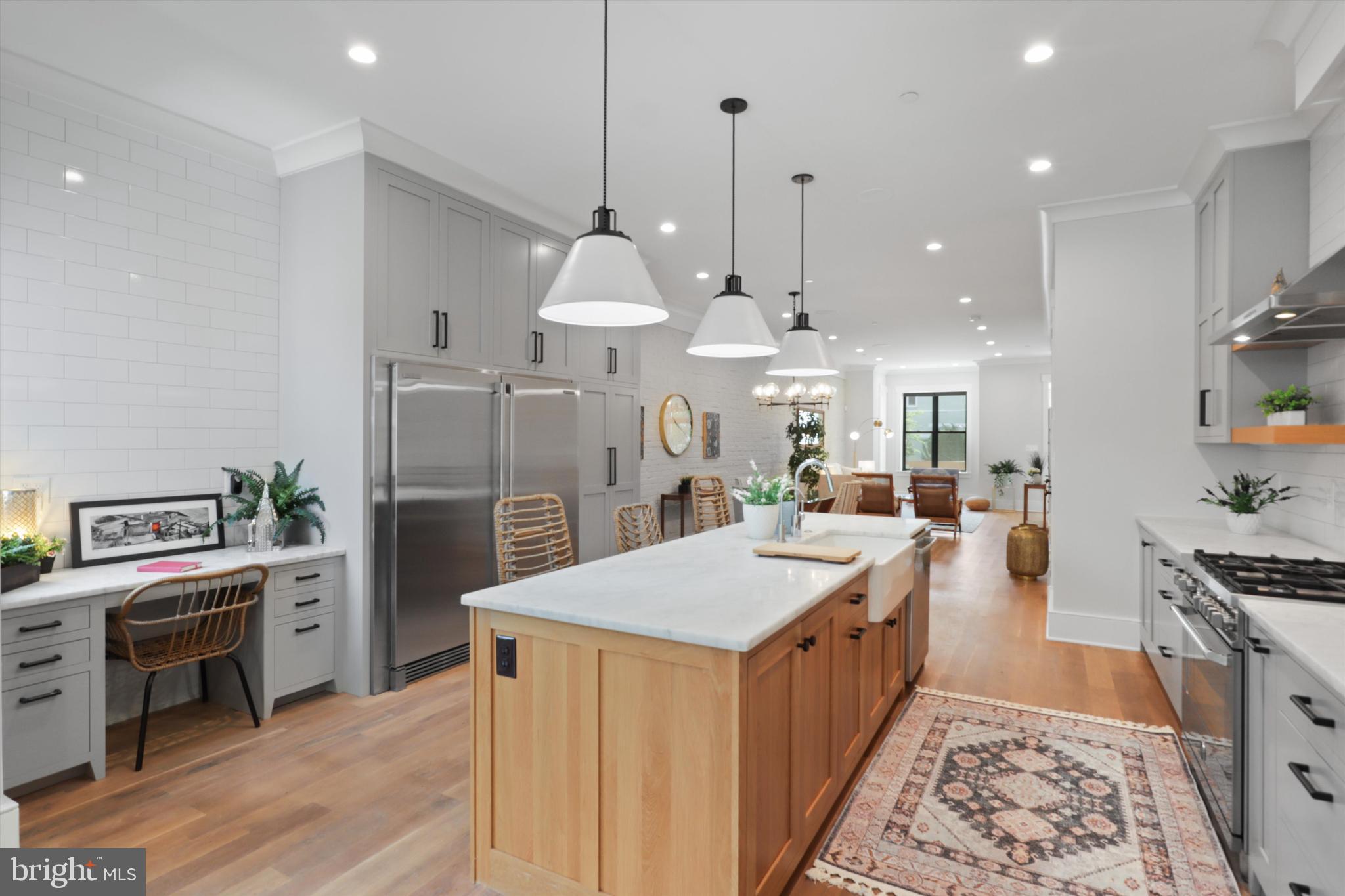1432 G Street Southeast Washington, DC 20003 - Photo 15 of 56 a large kitchen with stainless steel appliances a large counter top a stove a sink and a refrigerator