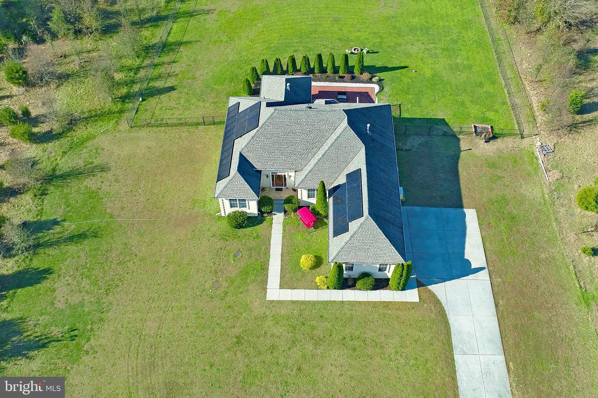 an aerial view of a house with swimming pool and yard