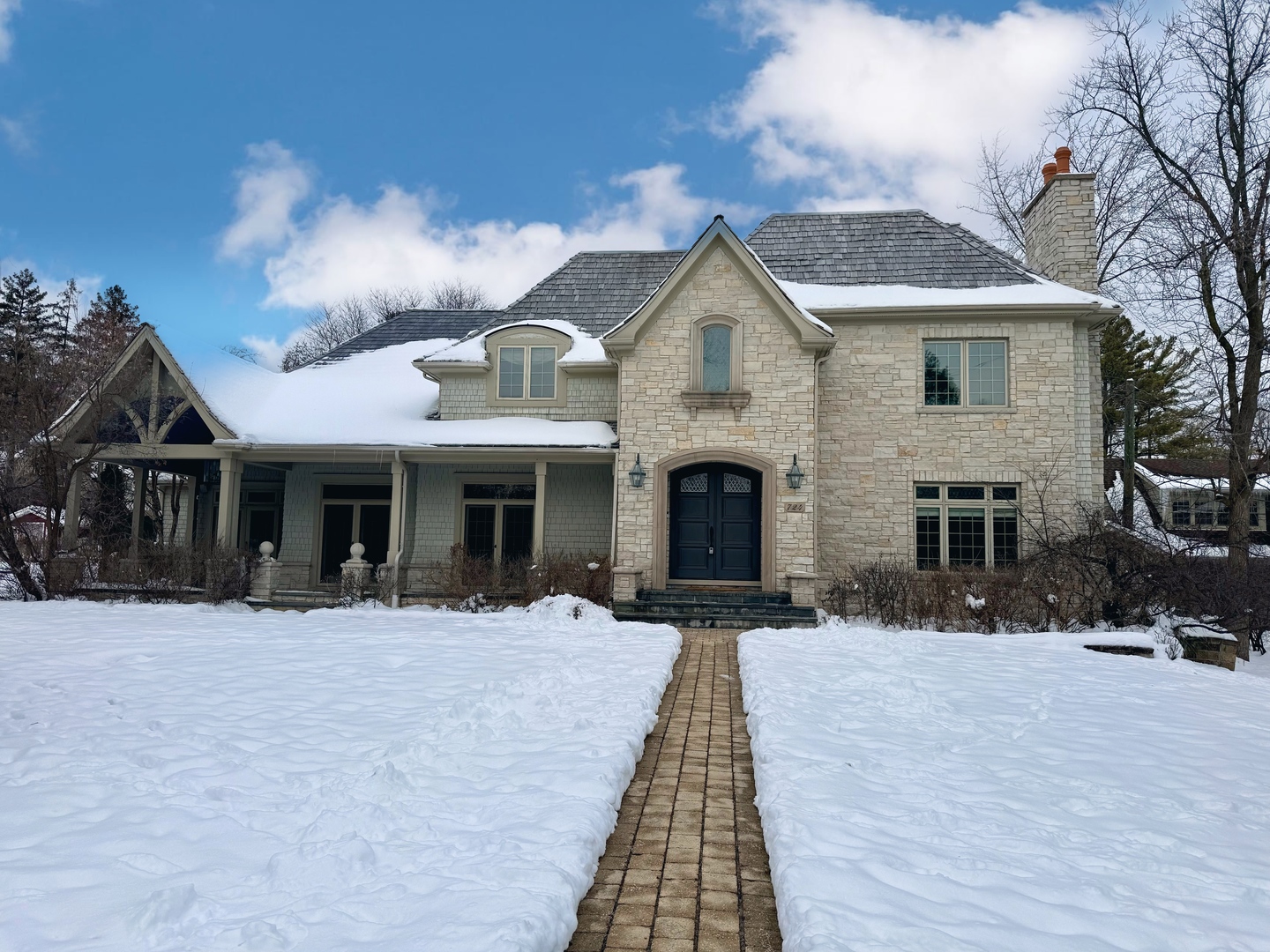 a front view of a house with a yard covered with trees