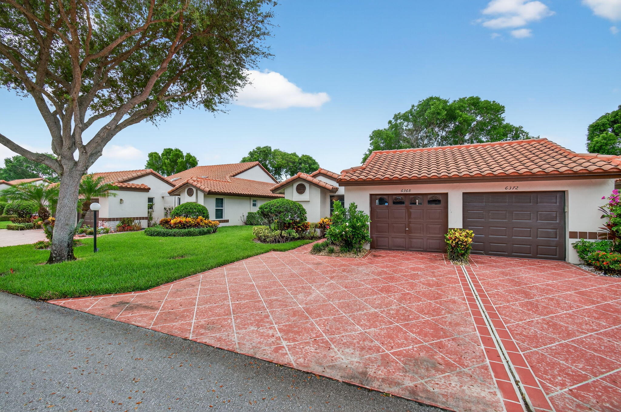 6368 Mill Pointe Circle Delray Beach, FL 33484 - Photo 3 of 132 a view of a white house with a yard plants and large tree
