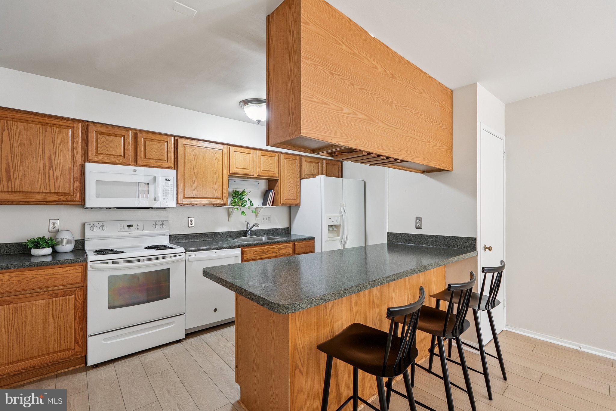 2343 Glade Bank Way Reston, VA 20191 - Photo 11 of 38 a kitchen with stainless steel appliances granite countertop a stove a sink and a microwave