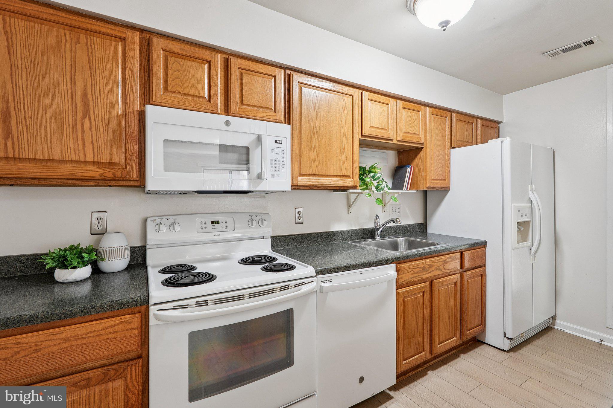 2343 Glade Bank Way Reston, VA 20191 - Photo 13 of 38 a kitchen with stainless steel appliances granite countertop a stove a sink and a refrigerator