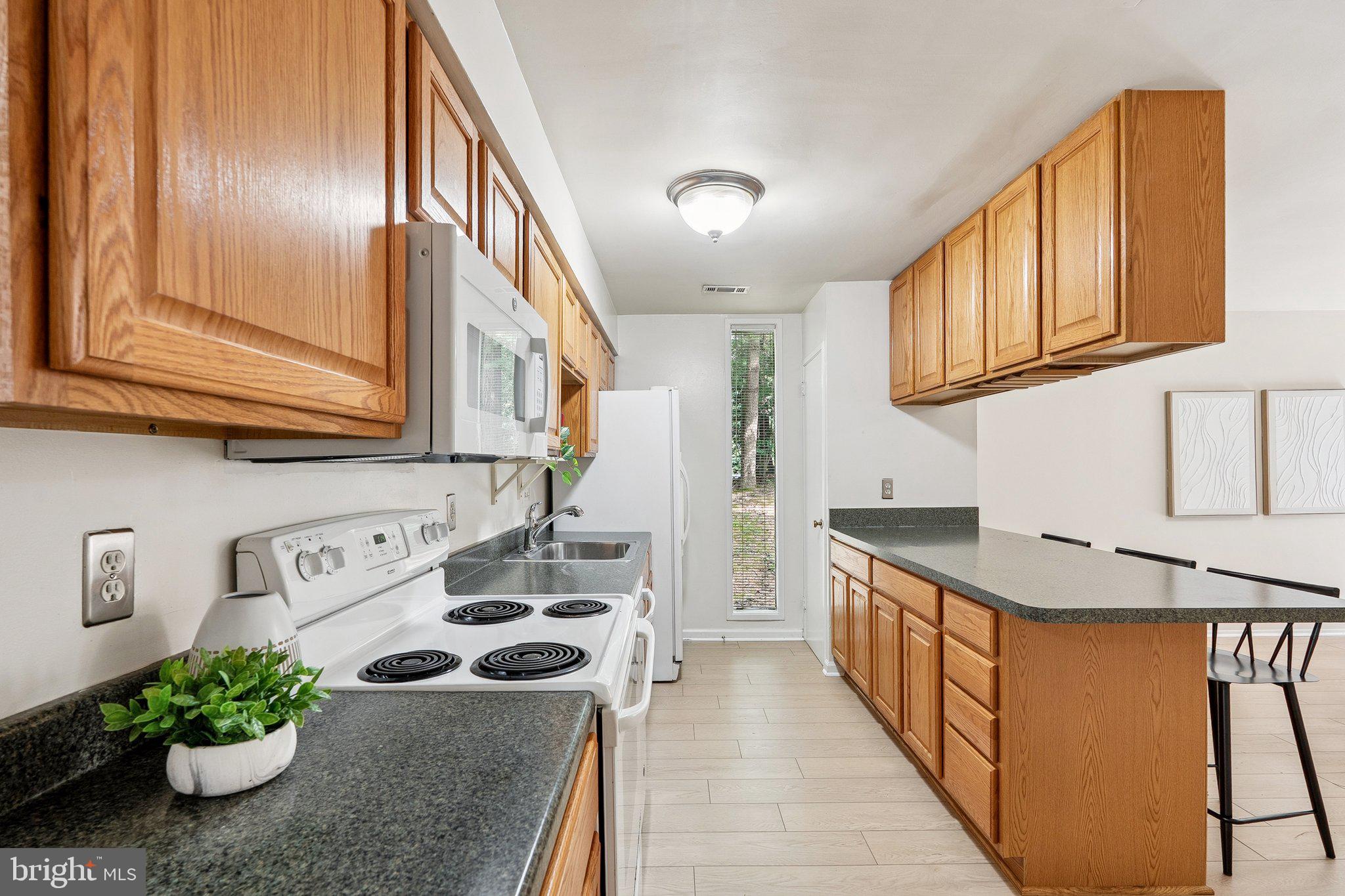 2343 Glade Bank Way Reston, VA 20191 - Photo 14 of 38 a kitchen with stainless steel appliances granite countertop a stove a sink and a refrigerator