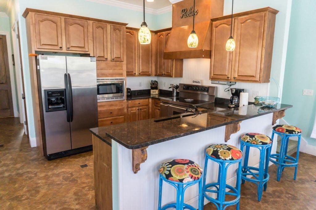 4554 Biscayne Way Destin, FL 32541 - Photo 10 of 33 a kitchen with stainless steel appliances granite countertop a sink a refrigerator and a counter space