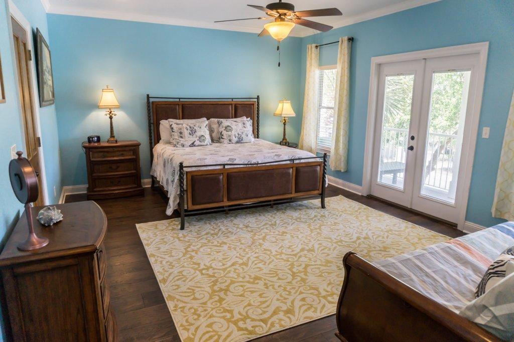 4554 Biscayne Way Destin, FL 32541 - Photo 14 of 33 a bedroom with a bed and a chandelier