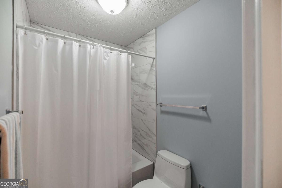 835 Timothy Road Athens, GA 30606 - Photo 47 of 65 a bathroom with a shower curtain and toilet