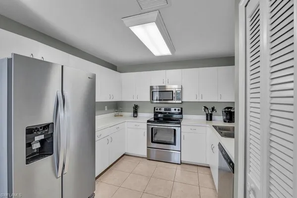 a kitchen with stainless steel appliances a refrigerator sink and stove