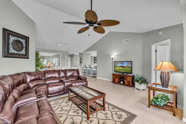 a living room with furniture a ceiling fan and a window