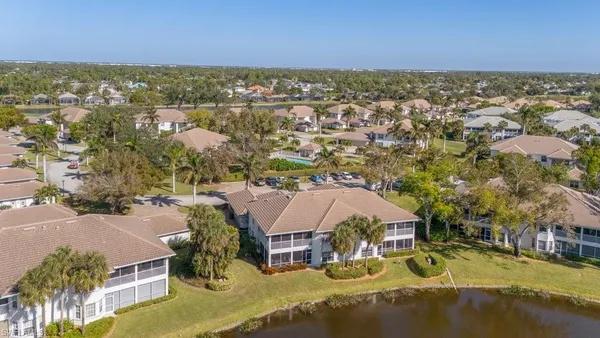 an aerial view of residential houses with outdoor space and trees