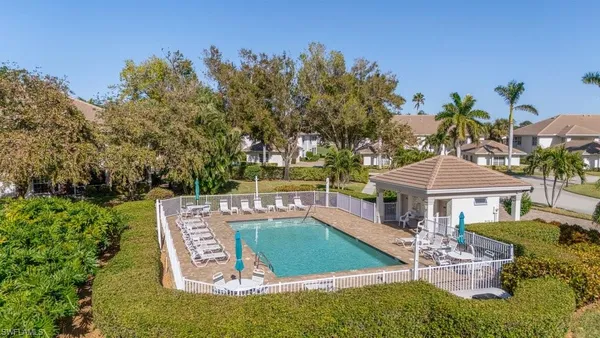 a view of a house with pool and chairs
