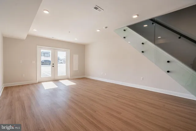 a view of an empty room with wooden floor