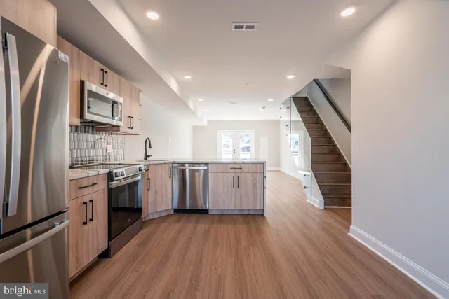 a kitchen with stainless steel appliances sink refrigerator and cabinets