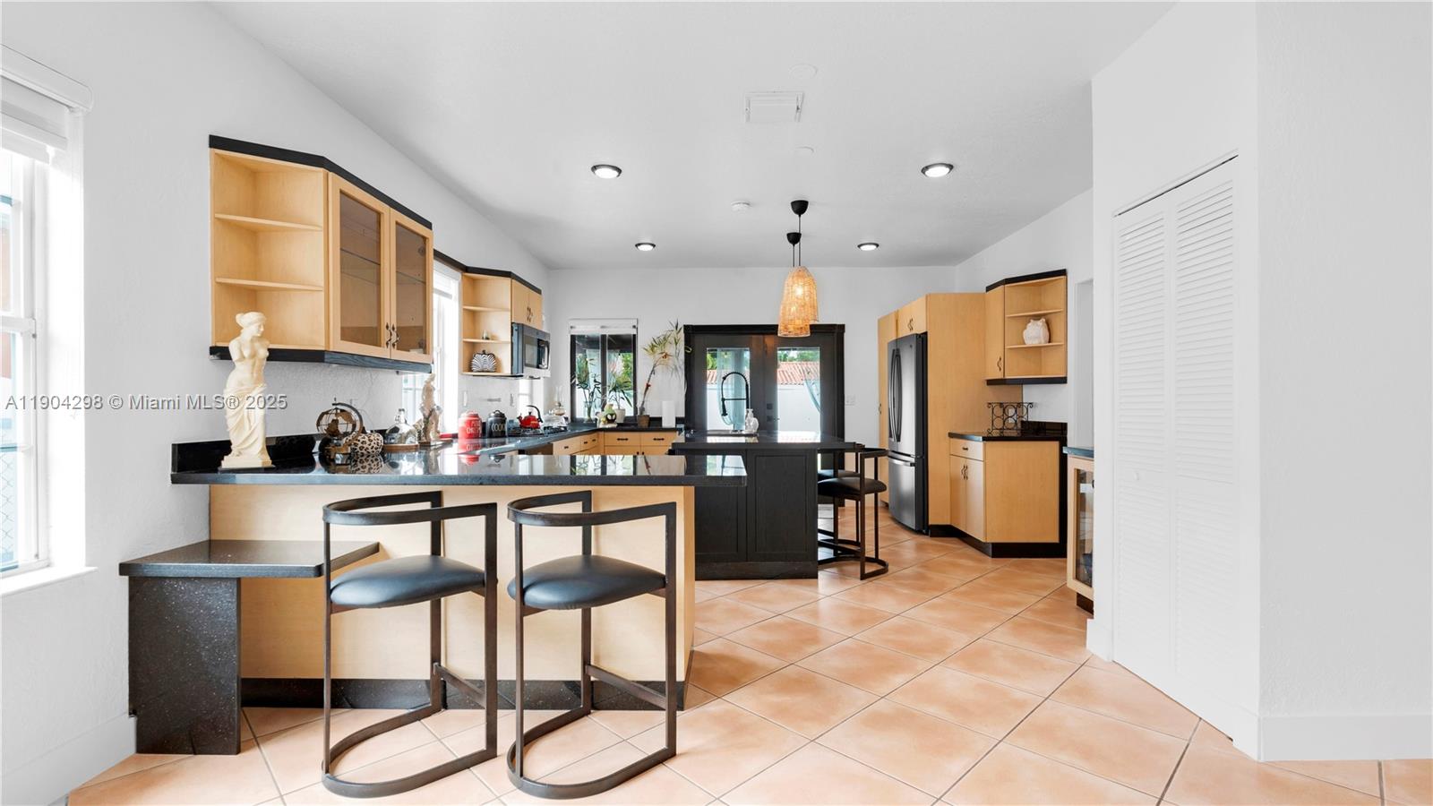 2271 Southwest 25th Street, Unit 2271 Miami, FL 33133 - Photo 11 of 39 a kitchen with stainless steel appliances kitchen island granite countertop a refrigerator and cabinets