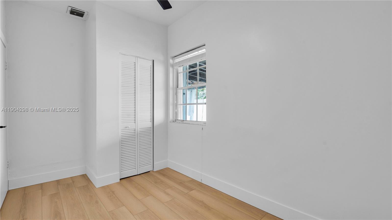 2271 Southwest 25th Street, Unit 2271 Miami, FL 33133 - Photo 26 of 39 a view of an empty room with wooden floor and a window