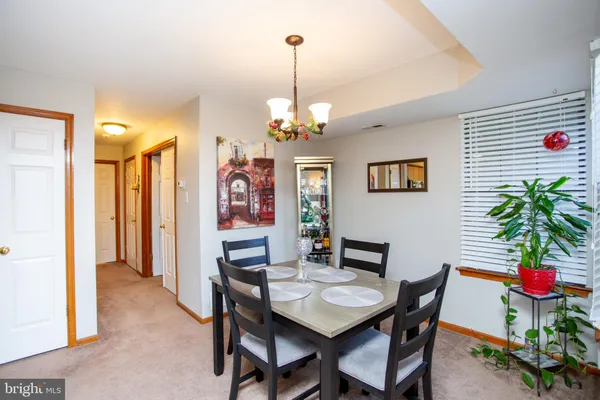 a view of a dining room with furniture and chandelier