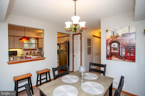a dining room with wooden floor a chandelier a wooden table and chairs