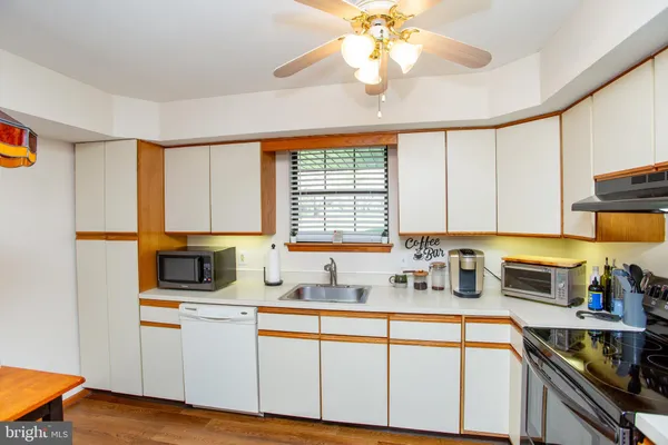 a kitchen with stainless steel appliances granite countertop a sink a stove cabinets counter space and a window