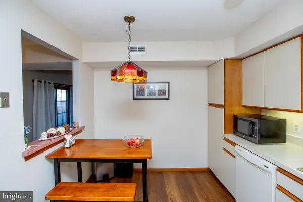 a kitchen with stainless steel appliances kitchen island a table and chairs in it