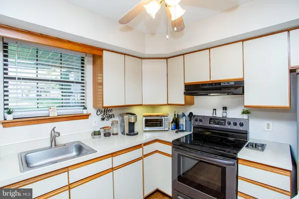 a kitchen with granite countertop a sink a counter top space stainless steel appliances and cabinets