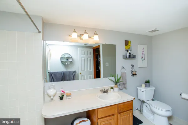 a bathroom with a sink vanity mirror and toilet