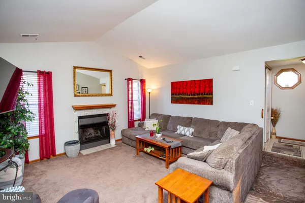 a living room with furniture a rug and a fireplace