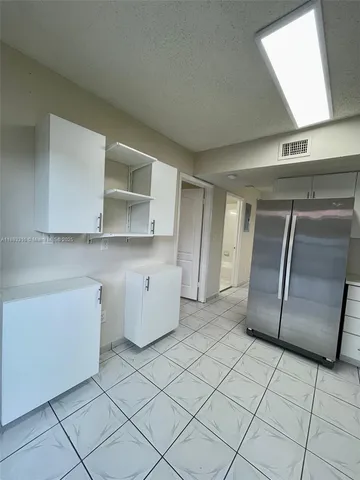 a kitchen with a refrigerator a stove top oven and cabinets