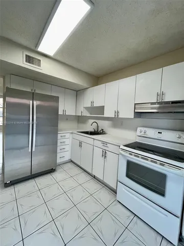 a kitchen with cabinets and steel stainless steel appliances