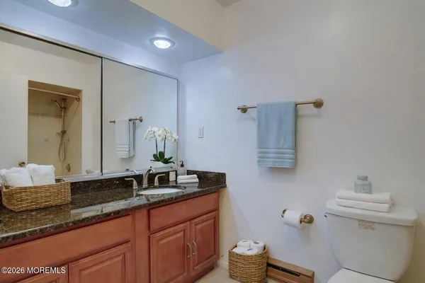 a bathroom with a granite countertop sink and a mirror
