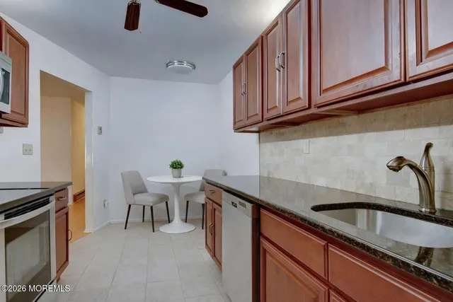 a kitchen with stainless steel appliances granite countertop a sink stove and cabinets