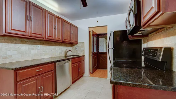 a kitchen with stainless steel appliances granite countertop a refrigerator and a sink