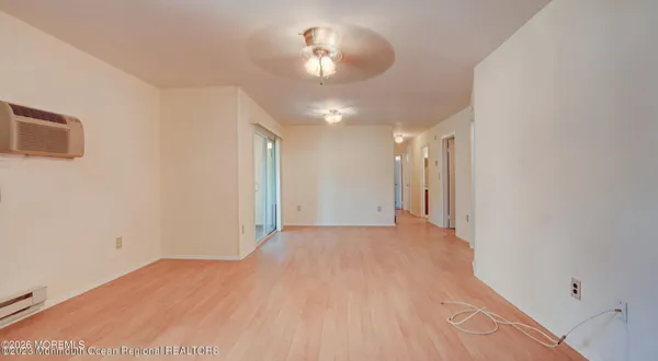 a view of an empty room and chandelier fan