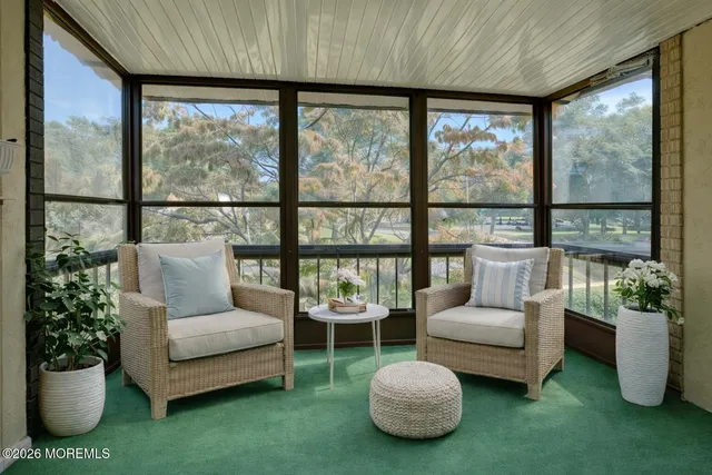 a living room with furniture and a floor to ceiling window