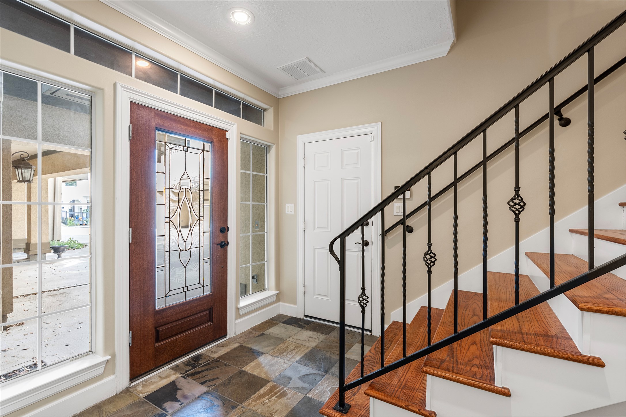 408 Fowler Street Houston, TX 77007 - Photo 2 of 24 The home opens with a slate-tiled entry and wrought iron staircase—setting the tone for elevated style throughout.