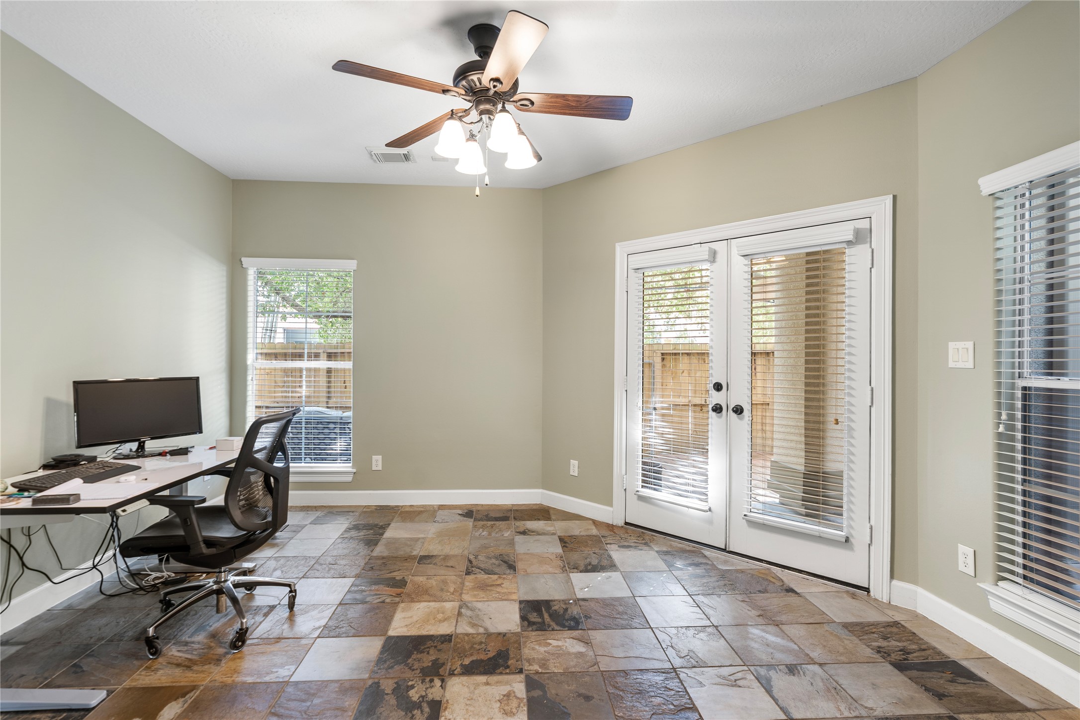 408 Fowler Street Houston, TX 77007 - Photo 3 of 24 Spacious ground-level room with tile floors, perfect as a guest suite or home office—features direct access to the private patio.