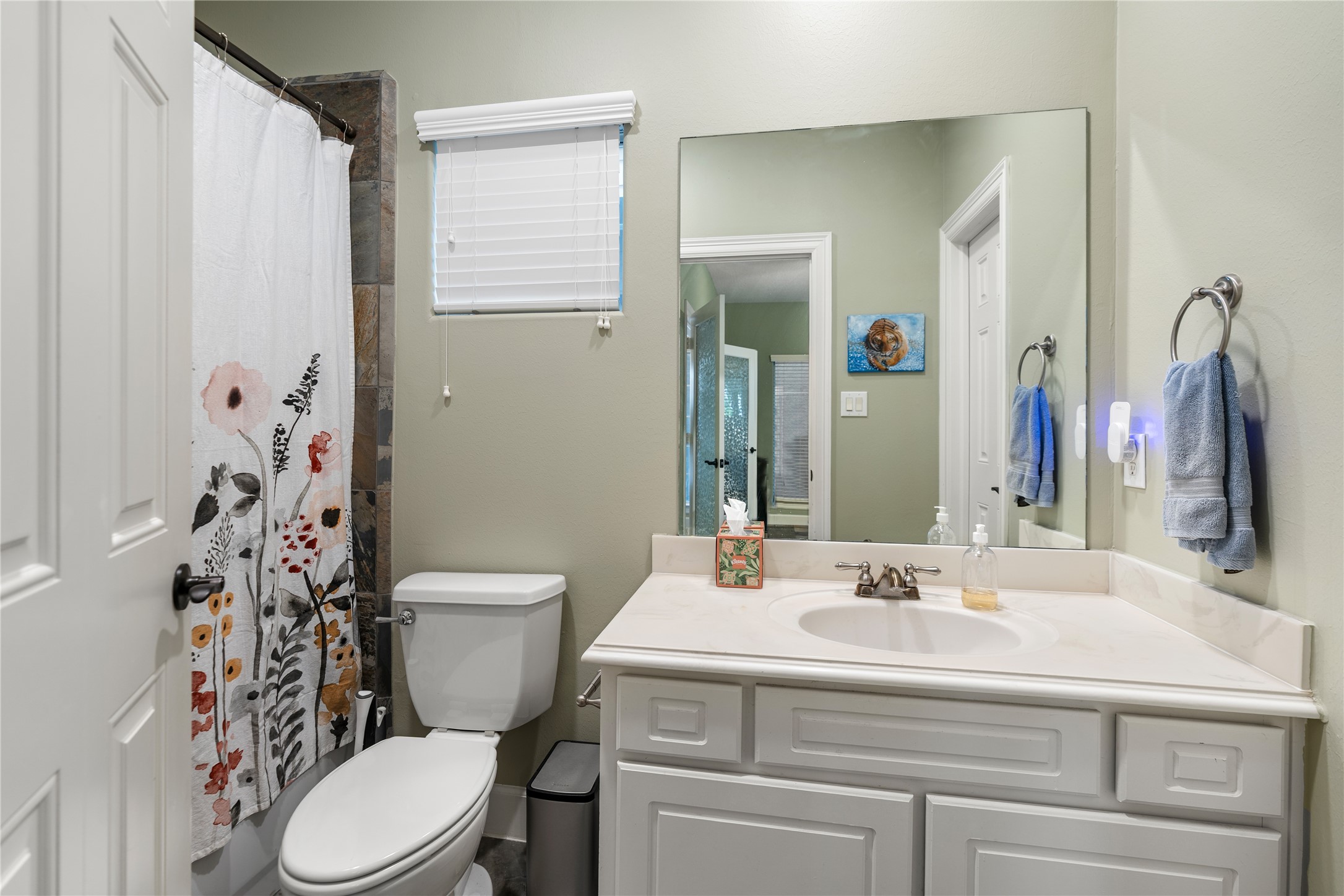 408 Fowler Street Houston, TX 77007 - Photo 4 of 24 Connected to the downstairs bedroom, this full bath features neutral tones and slate accents for a clean, functional finish.