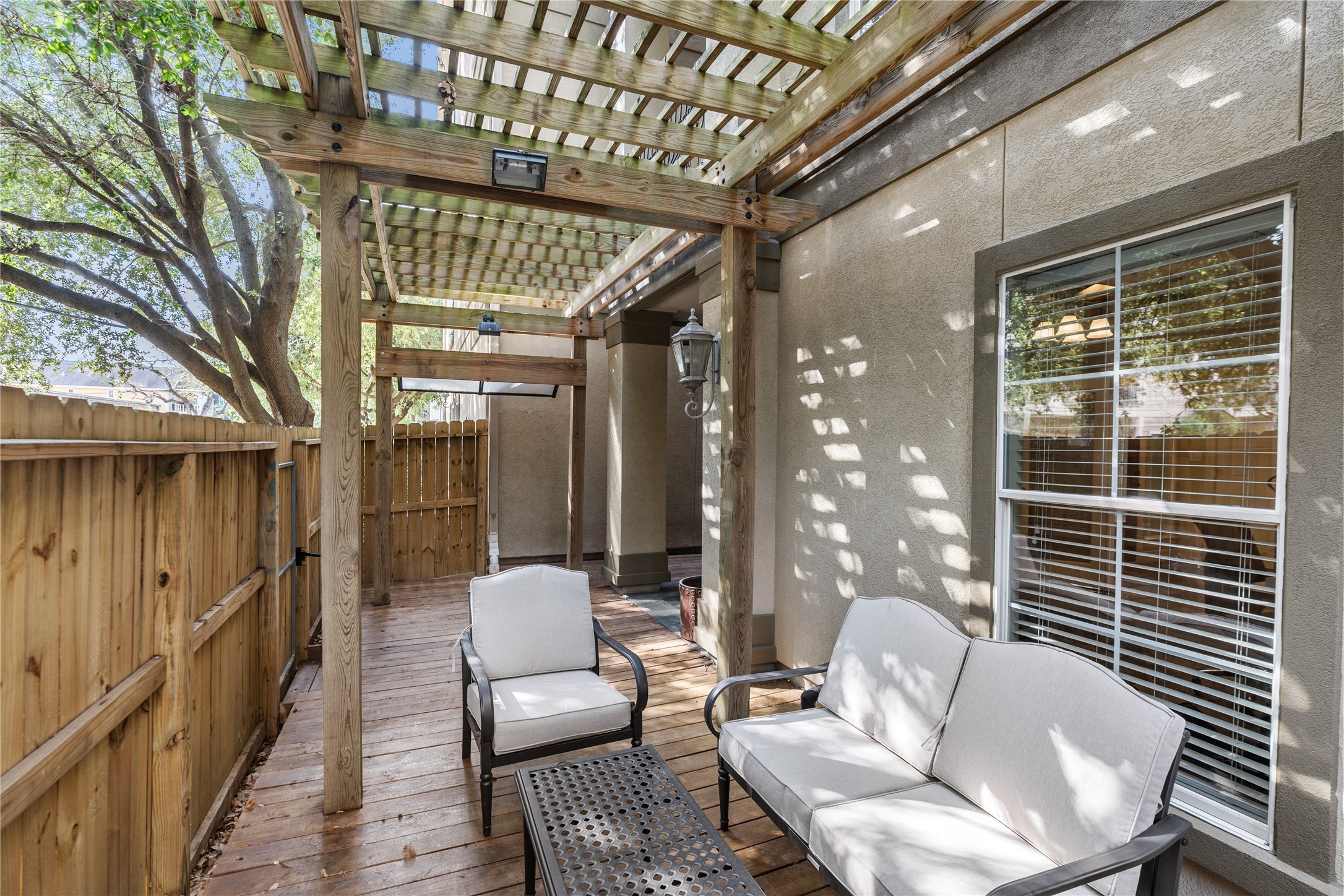 408 Fowler Street Houston, TX 77007 - Photo 6 of 24 This private patio is framed by mature trees and offers a cozy seating area under the new pergola—an inviting space for quiet mornings or evening gatherings.