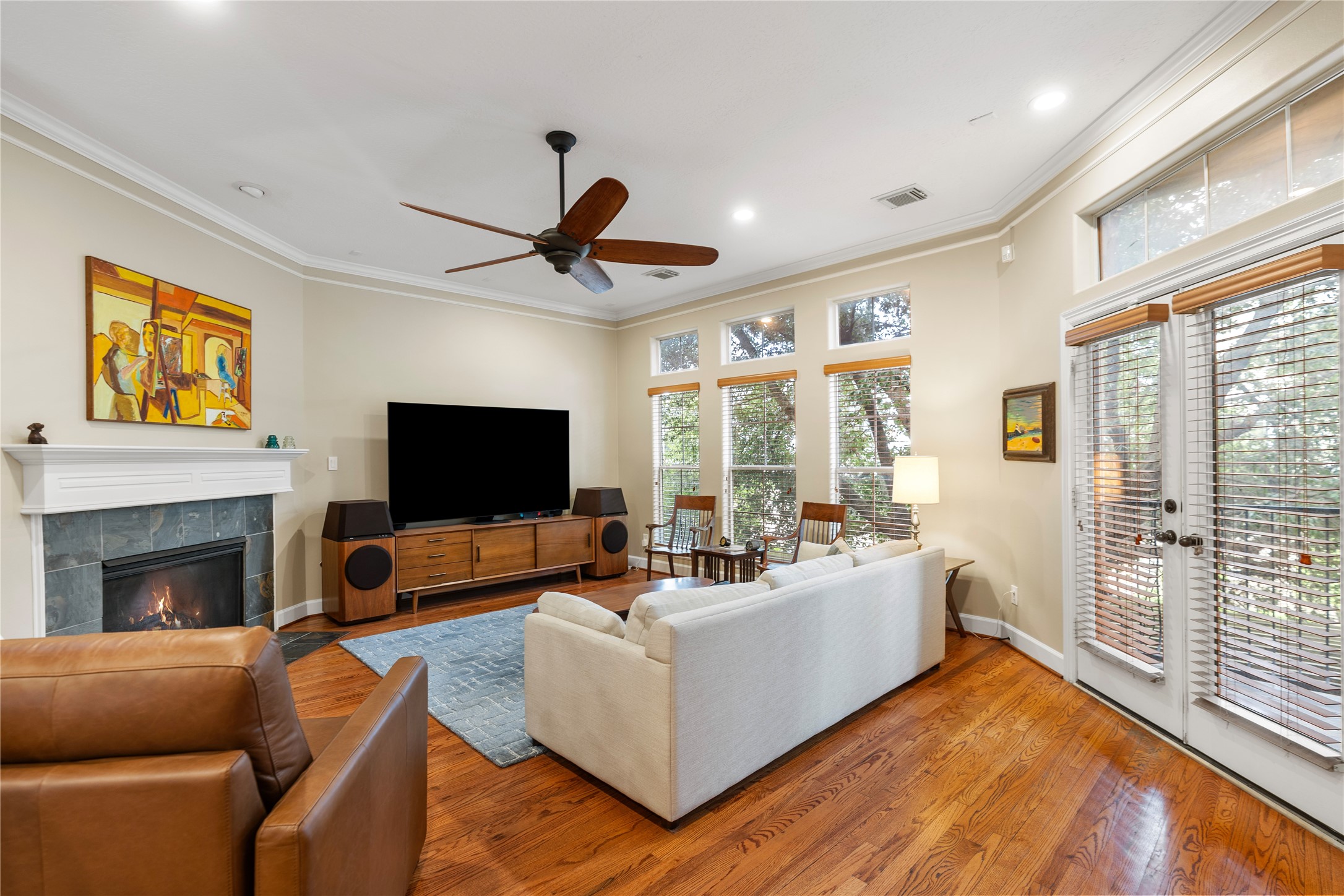 408 Fowler Street Houston, TX 77007 - Photo 7 of 24 This spacious living area features a gas fireplace, crown molding, and French doors opening to a private balcony with tree-lined views.