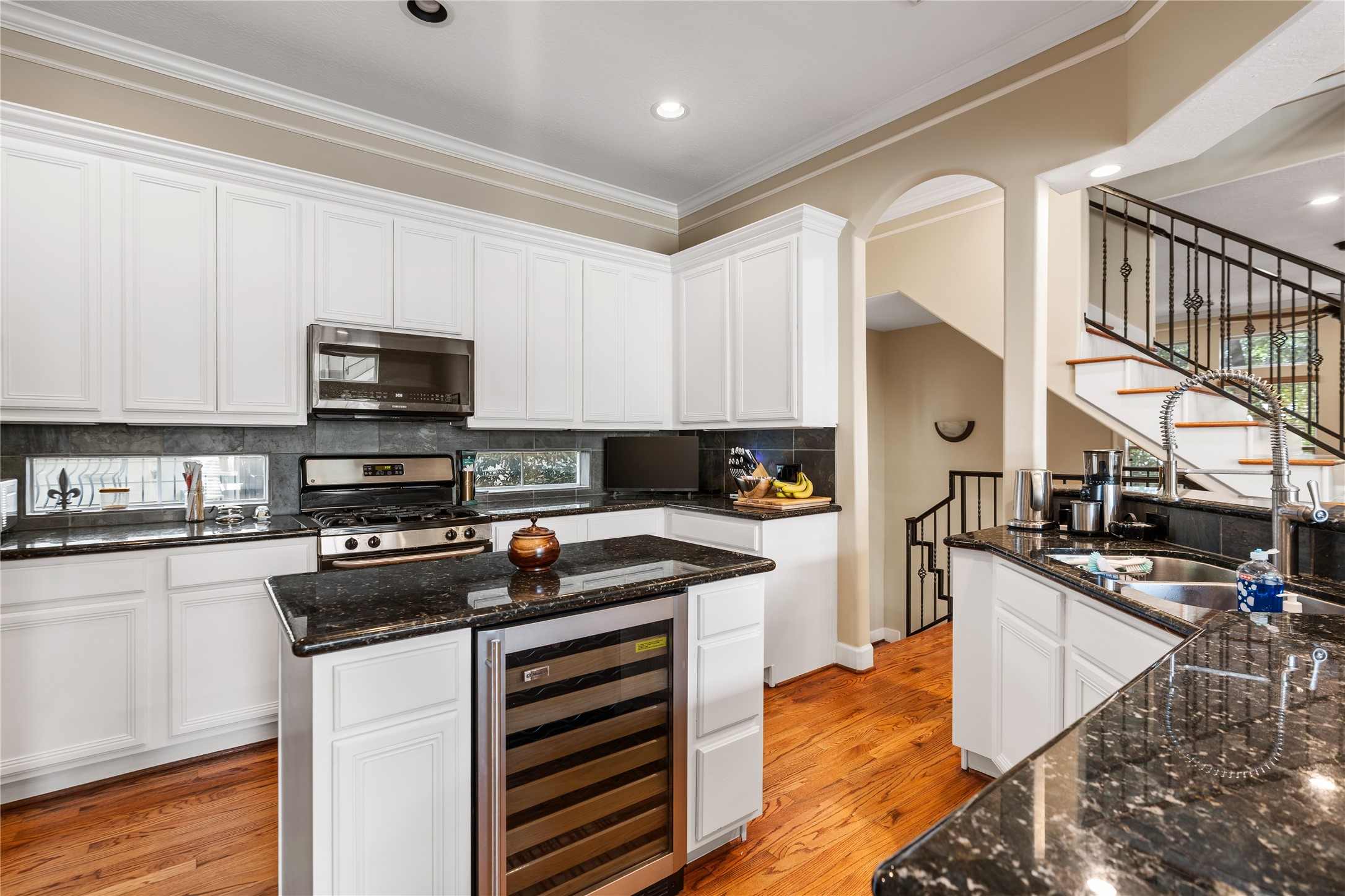 408 Fowler Street Houston, TX 77007 - Photo 10 of 24 Recently refreshed with painted cabinets, this kitchen features granite countertops, stainless appliances, and a large center island with built-in wine/beverage fridge