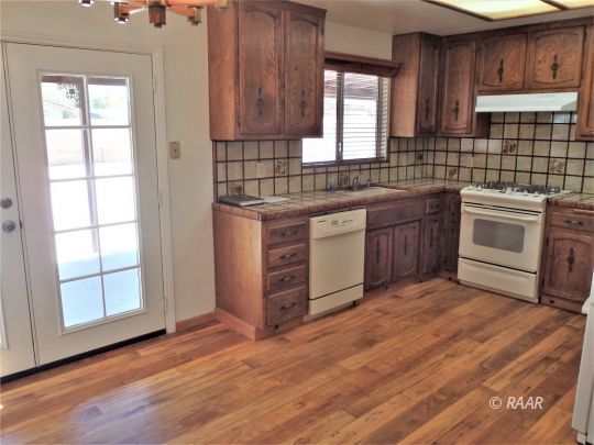 601 Weiman Avenue Ridgecrest, CA 93555 - Photo 13 of 35 a kitchen with stainless steel appliances granite countertop a stove a sink and a microwave
