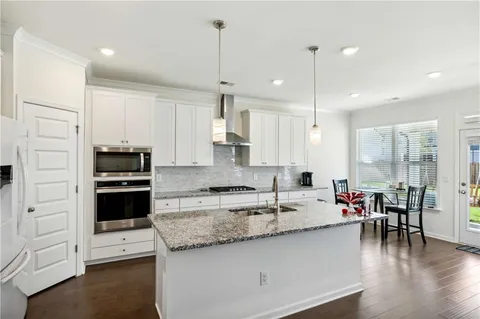 a kitchen with stainless steel appliances granite countertop a stove a sink and a refrigerator