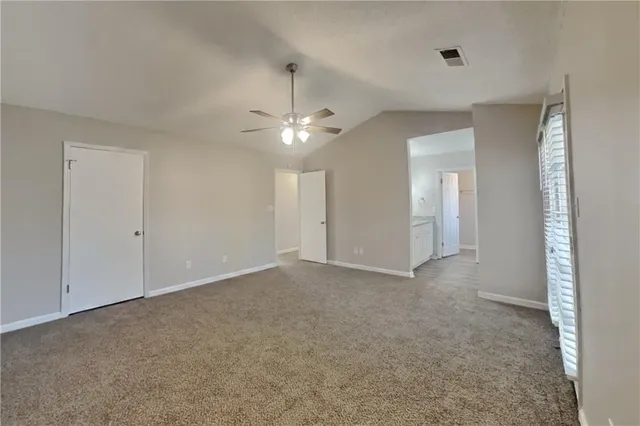 a view of an empty room with a ceiling fan
