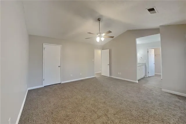 an empty room with a ceiling fan and a bathroom