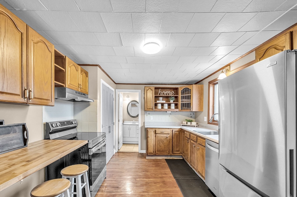 10 Kelsey Street East Longmeadow, MA 01028 - Photo 11 of 28 a kitchen with stainless steel appliances granite countertop a refrigerator a sink dishwasher a stove and white countertops with wooden floor