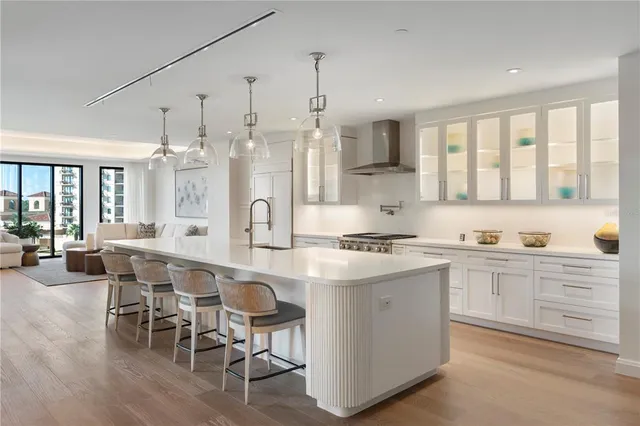 a large kitchen with kitchen island granite countertop lots of white cabinets appliances and furniture