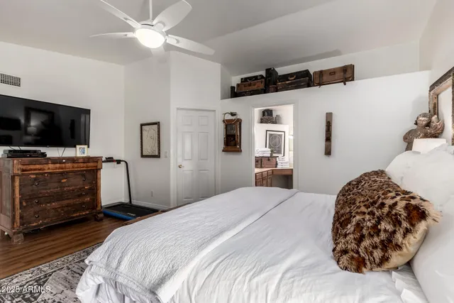 a bedroom with a bed and a flat tv screen on the dresser