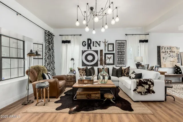 a living room with furniture a chandelier and a rug